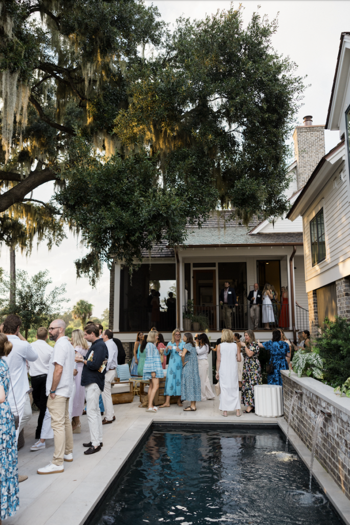 People mingling by pool at the opening party at the Southern Living Idea House